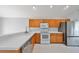 Kitchen with wood cabinets, white countertops, and stainless steel appliances at 8111 Tar Hollow Dr, Gibsonton, FL 33534
