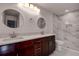 Elegant bathroom with double vanity, marble tile and circular mirrors at 10237 Carrin Rd, Spring Hill, FL 34608