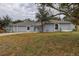 Newly renovated single-story home with a gray exterior and well-maintained lawn at 10237 Carrin Rd, Spring Hill, FL 34608