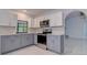 Modern kitchen with gray and white cabinets, stainless steel appliances and granite countertops at 10237 Carrin Rd, Spring Hill, FL 34608