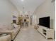 Living room with sofa, flat screen TV and view to kitchen at 11511 113Th St # 13H, Largo, FL 33778