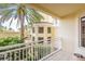 Private balcony overlooking a lush courtyard with palm trees at 1200 Gulf Blvd # 204, Clearwater Beach, FL 33767