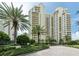 Luxury high-rise building with palm trees and a brick driveway at 1200 Gulf Blvd # 204, Clearwater Beach, FL 33767