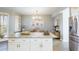 Kitchen island with granite countertop, white cabinets, and seating area at 1200 Gulf Blvd # 204, Clearwater Beach, FL 33767