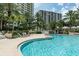 Curving pool with lounge chairs and palm trees at 1200 Gulf Blvd # 204, Clearwater Beach, FL 33767