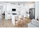 Modern white kitchen with island, stainless steel appliances, and light wood floors at 12269 New Tranquility Path, Venice, FL 34293