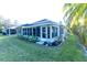 House exterior showcasing a well-maintained yard and sunroom addition at 1604 Boswell Ln, New Port Richey, FL 34655