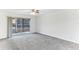 Bedroom with gray carpet, sliding glass doors to a balcony and ceiling fan at 200 Country Club Dr # 802, Largo, FL 33771