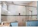 This bathroom showcases a glass shower with tan tiling, a rain shower head, and a granite countertop at 206 Church Ave, Bradenton Beach, FL 34217
