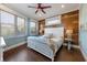 Bedroom with white bed, wood accent wall, and large windows at 206 Church Ave, Bradenton Beach, FL 34217