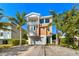 Three-story house with orange exterior, two-car garage, and landscaped yard at 206 Church Ave, Bradenton Beach, FL 34217
