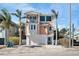 Charming three-story coastal home featuring a balcony, rounded windows, and a garage at 206 Church Ave, Bradenton Beach, FL 34217