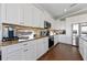 Bright kitchen with white cabinets, granite counters, and stainless appliances at 206 Church Ave, Bradenton Beach, FL 34217
