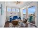 Cozy sitting area with a blue sofa, wicker chairs, and access to a balcony at 206 Church Ave, Bradenton Beach, FL 34217