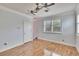 Bright bedroom with wood floors, ceiling fan, and large window with shutters at 214 Bon Vie Pl, Valrico, FL 33594
