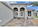 Inviting front entry with stone patio and arched doorway at 214 Bon Vie Pl, Valrico, FL 33594
