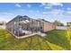 Home exterior showcasing a large backyard with a screened pool and patio area at 2424 Dakota Rock Dr, Ruskin, FL 33570