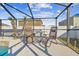 Relaxing pool area with screened enclosure, chairs, and small table at 2424 Dakota Rock Dr, Ruskin, FL 33570