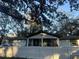 Charming house with white siding, a covered porch, and a fenced yard at 3005 E 148Th Ave, Lutz, FL 33559