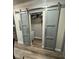 Well-lit laundry room with modern gray barn doors and vinyl flooring at 3005 E 148Th Ave, Lutz, FL 33559