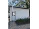 White storage shed with a paved pathway and landscaping at 3005 E 148Th Ave, Lutz, FL 33559
