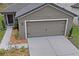 Front view of house with a two-car garage and landscaping at 30148 Fedora Cir, Brooksville, FL 34602