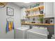 Bright laundry room with washer, dryer, and ample shelving at 30148 Fedora Cir, Brooksville, FL 34602