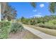 Walkway leads to a lush, private backyard with mature landscaping at 5610 Golden Isles Dr, Apollo Beach, FL 33572