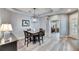 Bright dining room features a spacious table and chairs, hardwood floors, and a modern light fixture at 5610 Golden Isles Dr, Apollo Beach, FL 33572