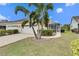 Home's exterior, featuring a two-car garage and lush landscaping at 5610 Golden Isles Dr, Apollo Beach, FL 33572