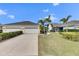 Two-car garage with white doors and landscaping at 5610 Golden Isles Dr, Apollo Beach, FL 33572