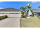 Two-car garage with white doors and landscaping at 5610 Golden Isles Dr, Apollo Beach, FL 33572
