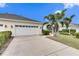Two-car garage with white doors and palm trees at 5610 Golden Isles Dr, Apollo Beach, FL 33572