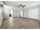 Bright bedroom featuring wood-look floors, ceiling fan, and ensuite bathroom access at 6008 49Th N Ave, Kenneth City, FL 33709