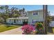 Green house with a two-car driveway, palm trees and lush lawn at 6008 49Th N Ave, Kenneth City, FL 33709