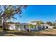 Green house with a two-car driveway and mature landscaping at 6008 49Th N Ave, Kenneth City, FL 33709