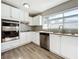 Bright kitchen boasts white cabinets, granite counters & stainless steel appliances at 6008 49Th N Ave, Kenneth City, FL 33709