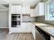 Renovated kitchen with white cabinets, granite countertops and stainless steel appliances at 6008 49Th N Ave, Kenneth City, FL 33709
