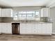 Modern kitchen with white cabinets, granite countertops and stainless steel dishwasher at 6008 49Th N Ave, Kenneth City, FL 33709