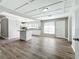 Open concept kitchen with island, white cabinets, and wood-look flooring at 6008 49Th N Ave, Kenneth City, FL 33709