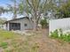 Backyard view of home with large tree and storage shed at 6509 S West Shore Cir, Tampa, FL 33616