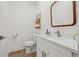 Simple half bathroom with white vanity and wood-look flooring at 8709 Palm Ranches Pl, Tampa, FL 33614