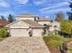Two-story house with a three-car garage and lush landscaping at 11550 Biddeford Pl, New Port Richey, FL 34654