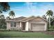 One-story home with light beige exterior, wood accents, and a two-car garage at 12199 Meditation Trl, Venice, FL 34293