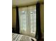 Bedroom with glass patio door, neutral curtains and a view of the outdoor patio at 130 Banyan Bay Dr, St Petersburg, FL 33705