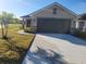 Single story home with a driveway and landscaping at 136110 Welsh Glade Rd, Dade City, FL 33525