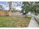 Large fenced backyard with mature trees and a spacious grassy area at 14430 10Th. St, Dade City, FL 33523