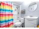 Bathroom with rainbow shower curtain and white vanity at 14430 10Th. St, Dade City, FL 33523