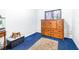 Bedroom with wood dresser, blue carpet, and window at 14430 10Th. St, Dade City, FL 33523