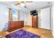 Bedroom with wood dresser, ceiling fan, and purple rug at 14430 10Th St, Dade City, FL 33523